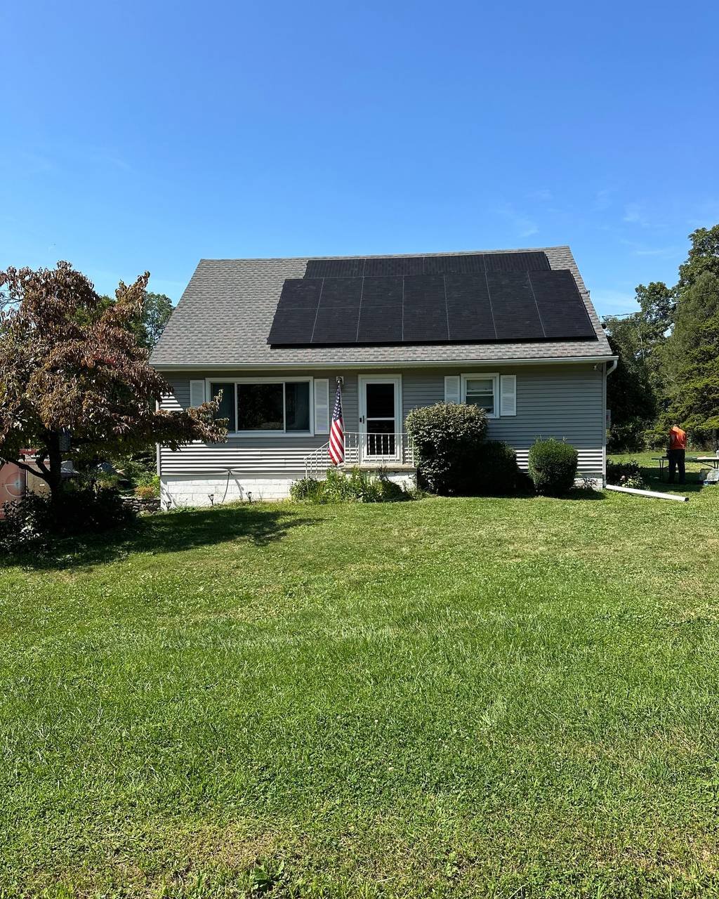 Cape Cod style home with a full roof of black solar panels