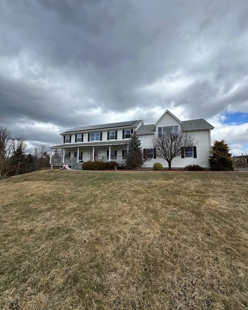 Large farmhouse on a hilltop with rooftop solar