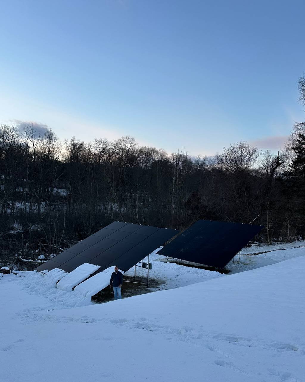 Ground-mounted solar array in a snowy yard