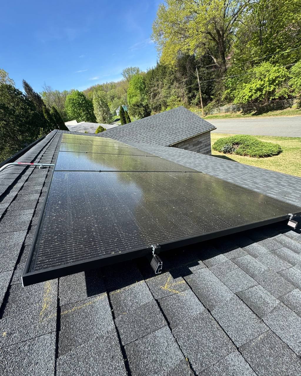 Close-up of solar panels mounted on an asphalt shingle roof