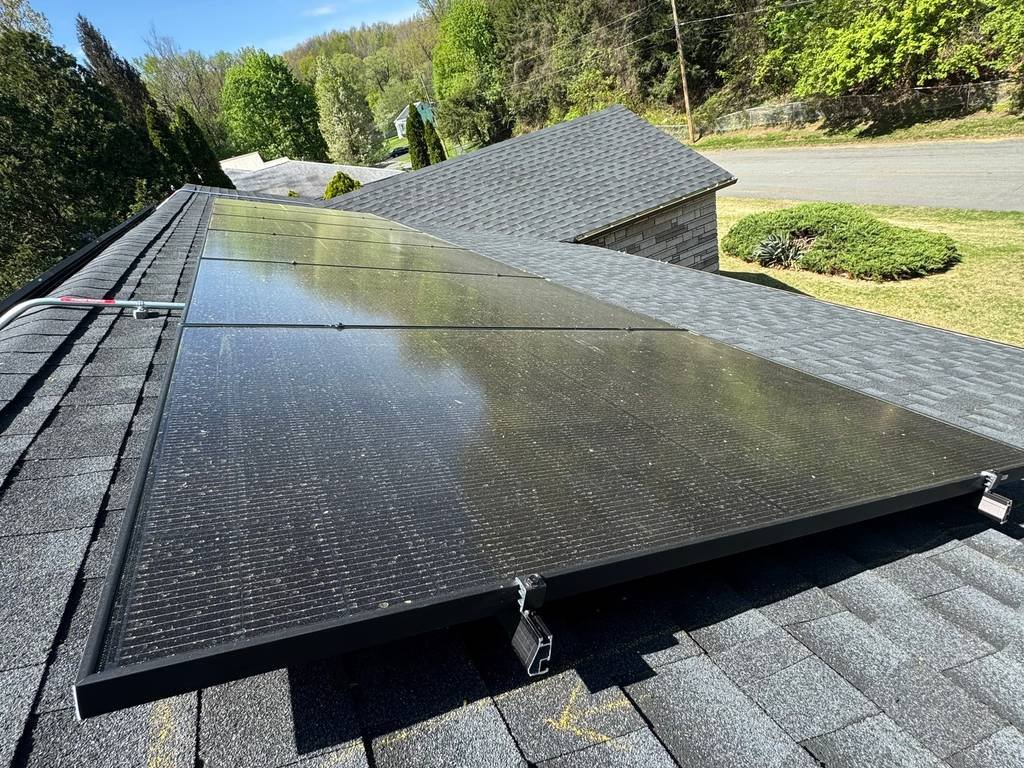 Close-up of solar panels mounted on an asphalt shingle roof