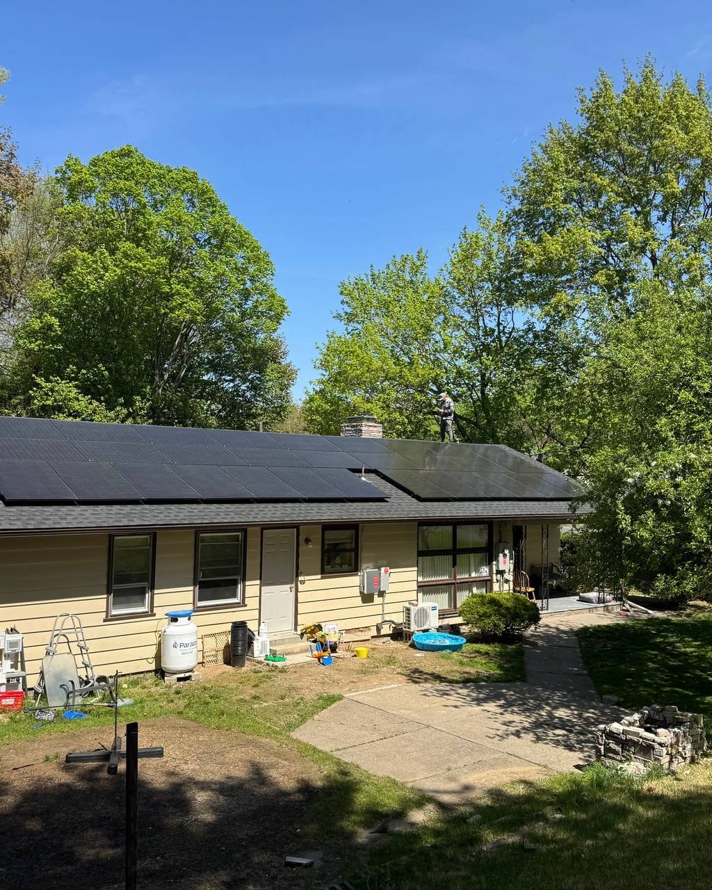 Ranch home with a solar array on the back roof, seen from the yard