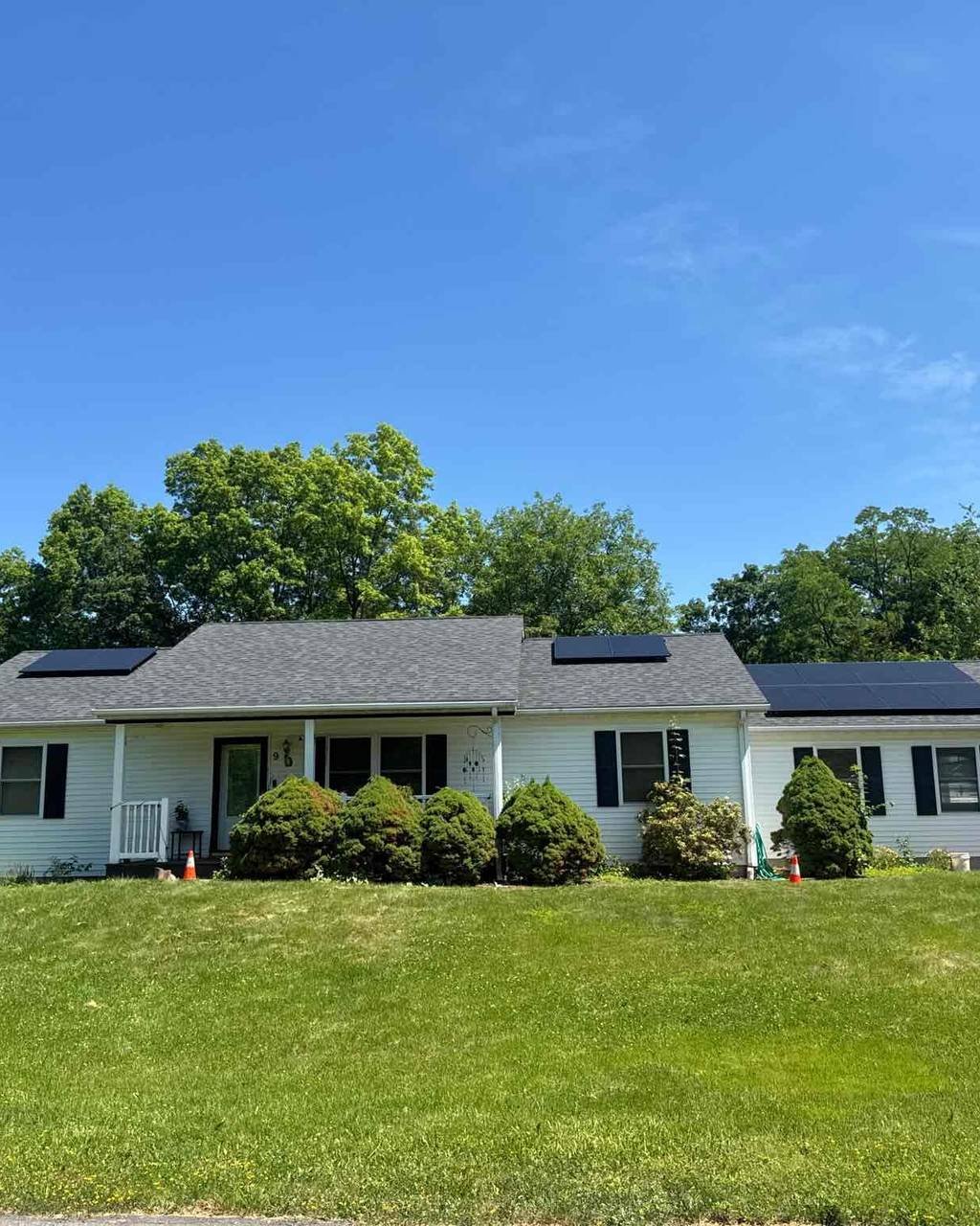 White ranch home with solar panels between the dormers